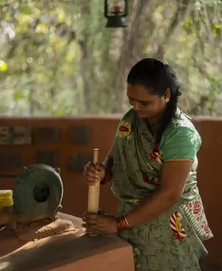 A cook preparing ingredients with traditional tools